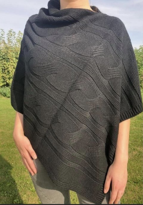 Flot sort poncho i strik med uld, og med snoet mønstre.