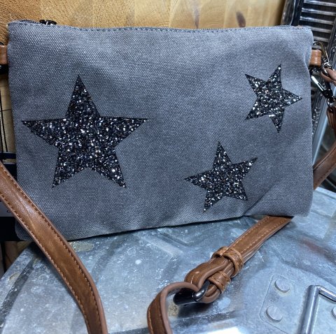 Grå canvas taske  med 3 mørk sølv stjerner. Har brune remme, der kan tages af eller justeres i længde. Str. 26 x 18 cm