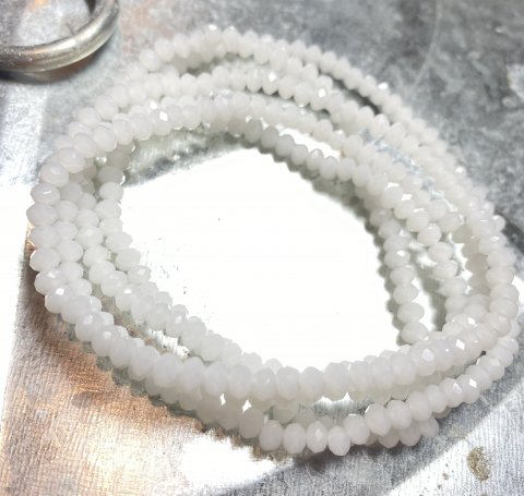 NY BILLIGERE FAST PRIS!! Mat hvid halskæde/armbånd. Små fine perler på elastik snor, der kan bruges til halskæde eller snores 5-6 gange om hånden og bruges til smart armbånd.