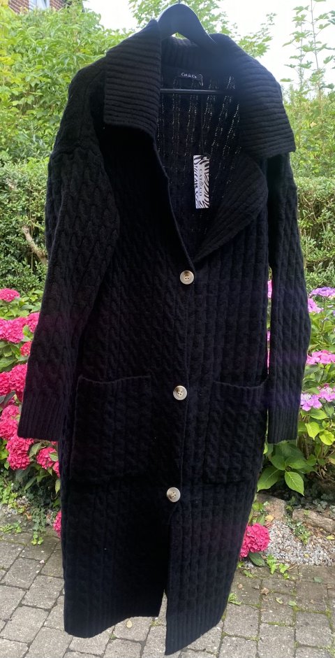 Super lkker kraftig sort strik cardigan, med flet mnster, krave og knapper til at lukke. Str. one side