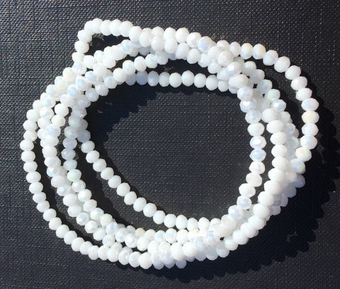 NY BILLIGERE FAST PRIS!! Hvid halskæde/armbånd. Små fine perler på elastik snor, der kan bruges til halskæde eller snores 5-6 gange om hånden og bruges til smart armbånd.