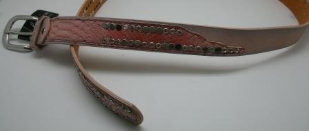 3 ½ cm rosafarvet læder bælte, med kunstlæder på forsiden, første og sidste stykke i snakelook med nitter og similisten. Let at gøre kortere. Str. 95 og 100.